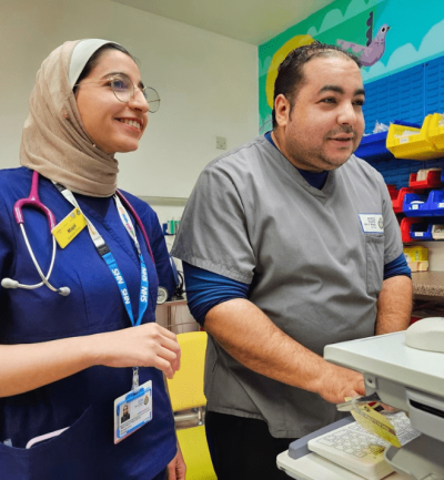 One female and one male nurse looking at a computer screen